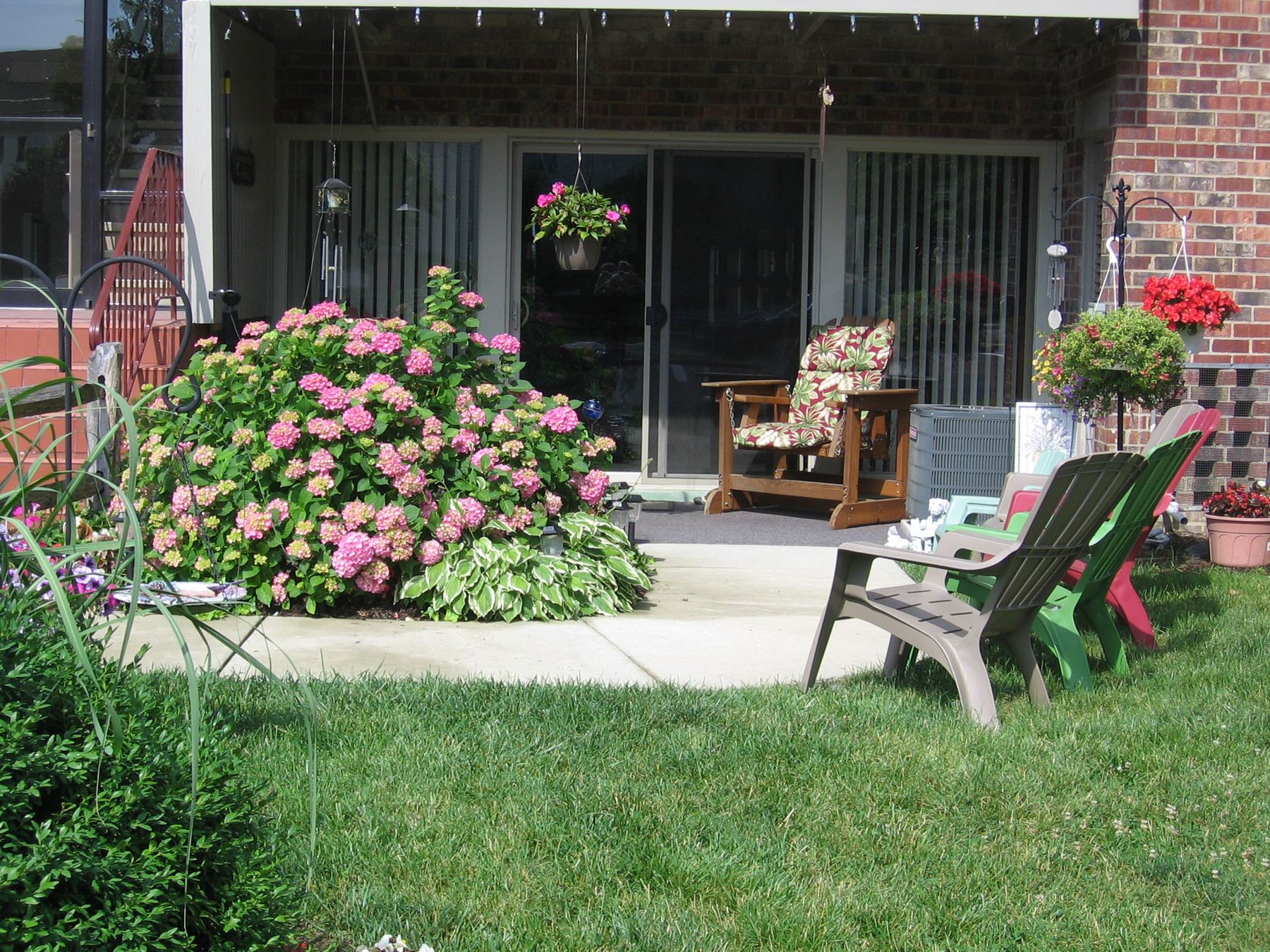 Ground-floor patio with flowering hydrangeas and garden chairs