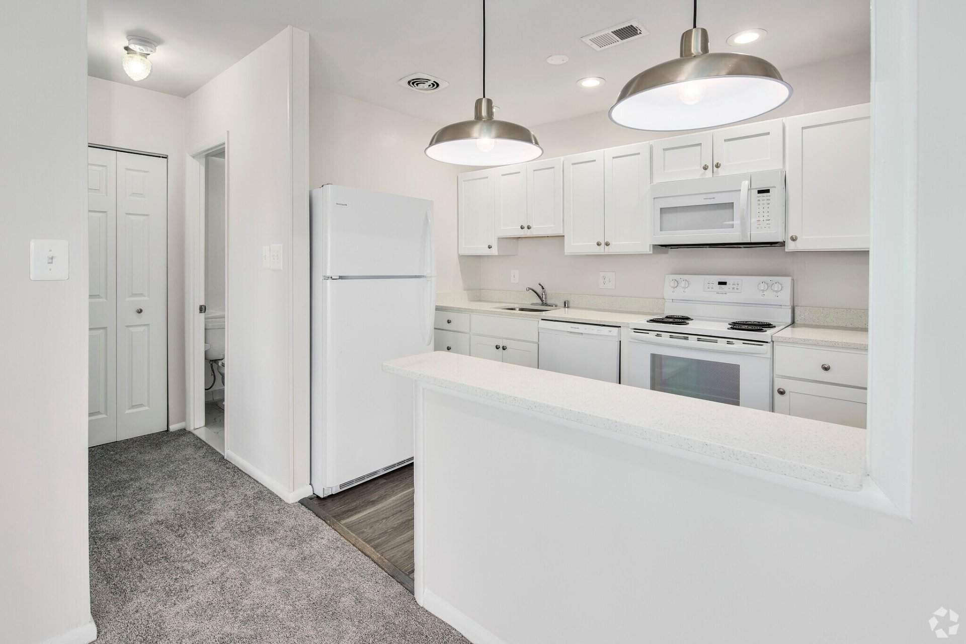 Renovated white kitchen with pendant lights and a breakfast bar