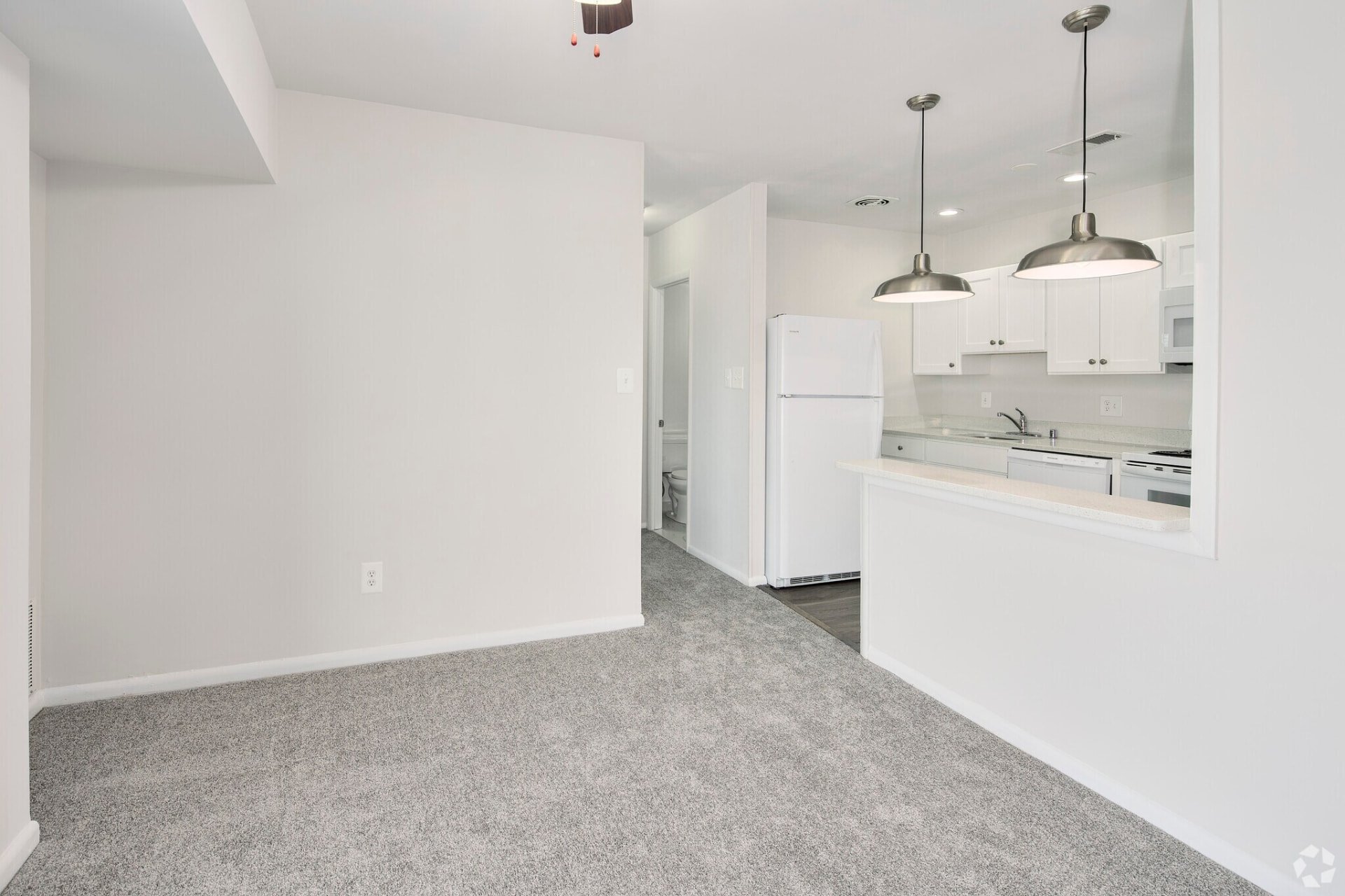 One-bedroom dining area beside the white kitchen