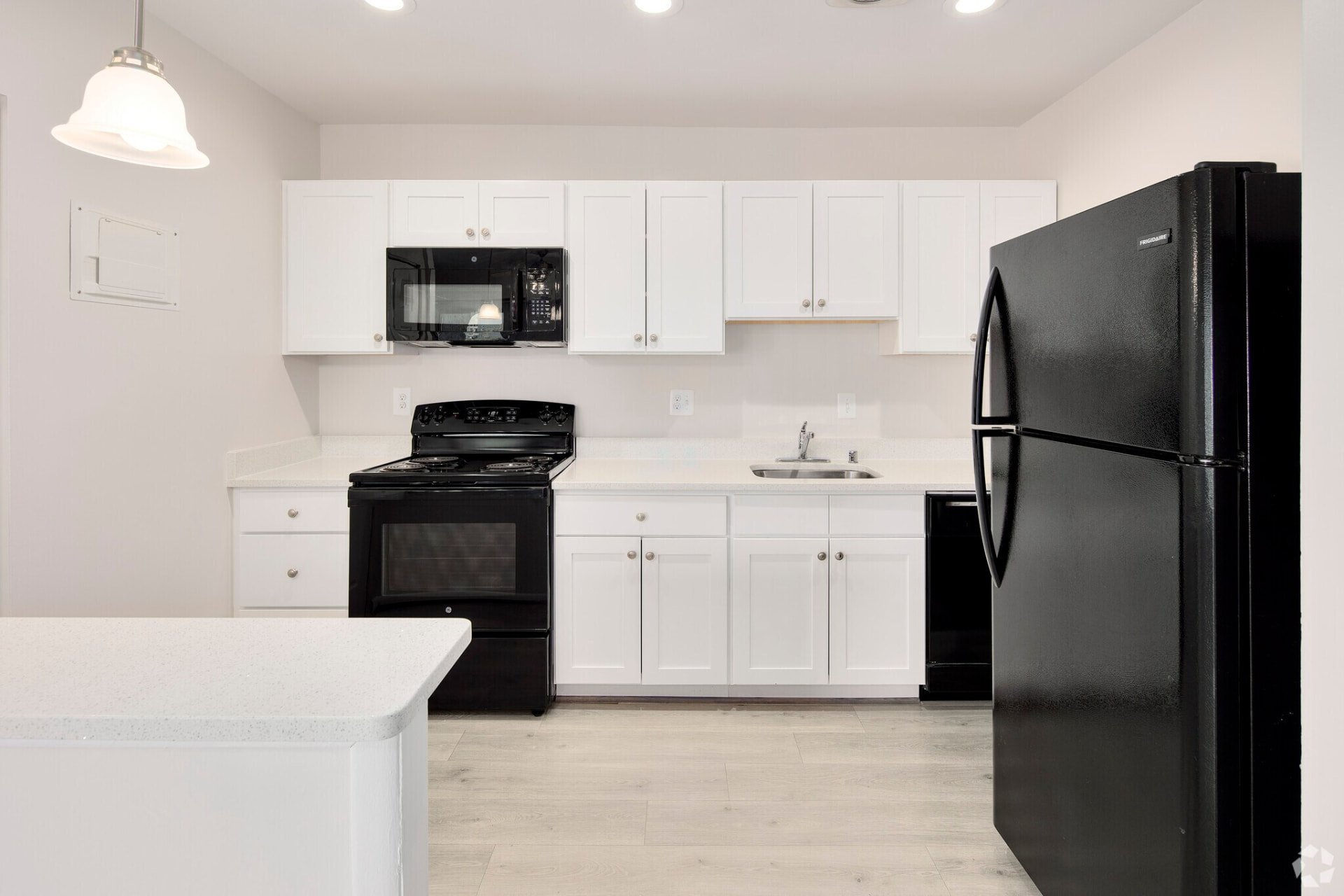 Two-bedroom white kitchen with black refrigerator and stove