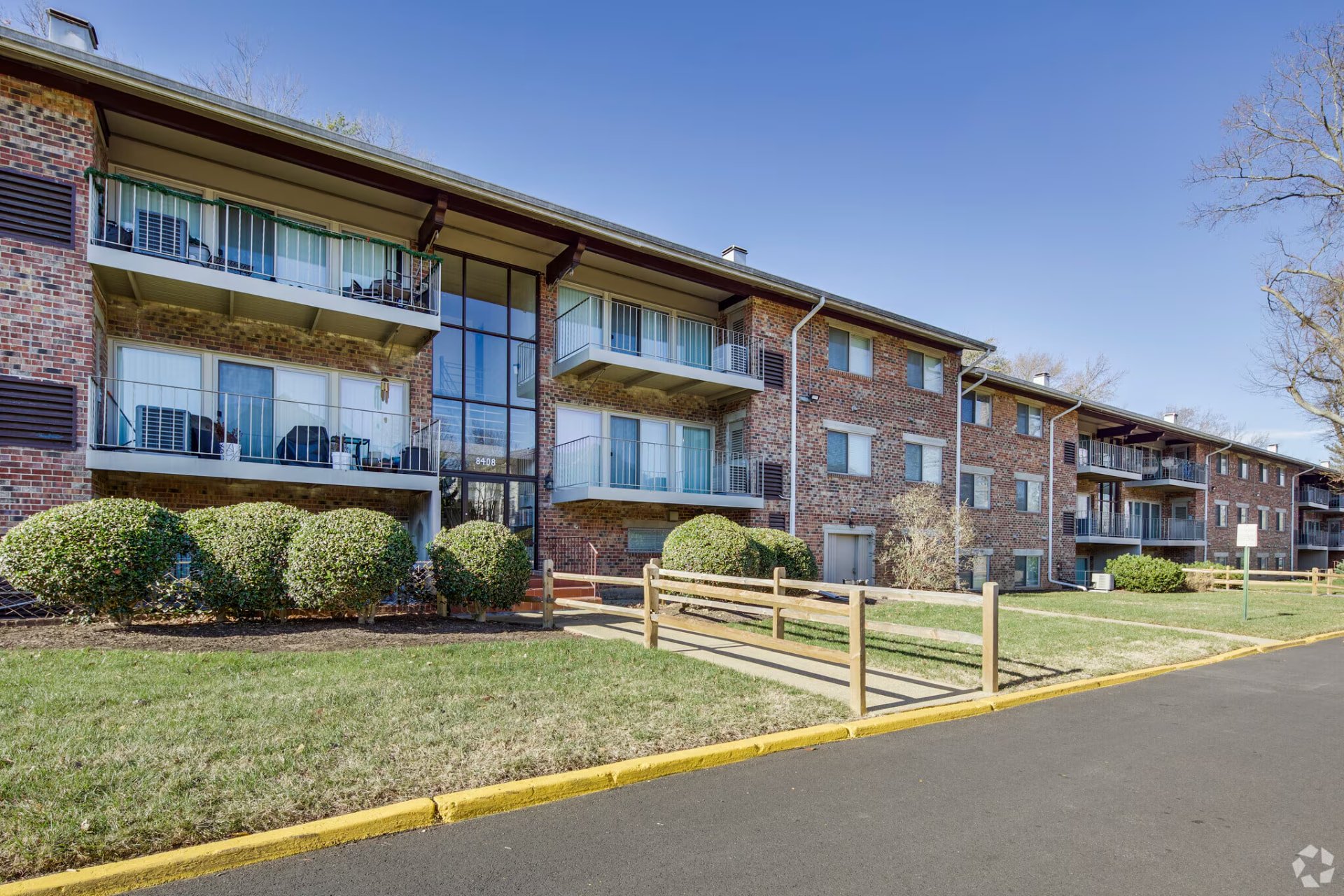Skyview brick apartment buildings with balconies and landscaped lawn