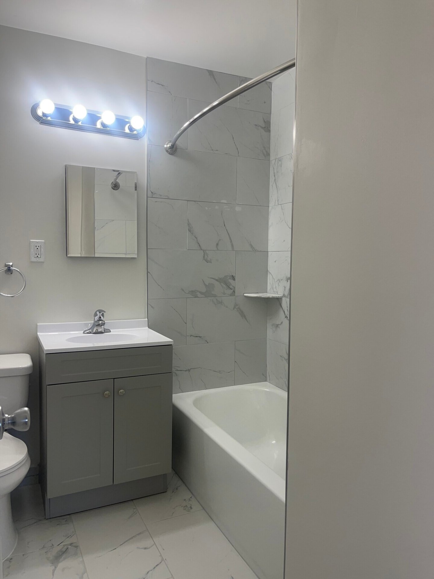 Bathroom with gray vanity and tiled shower