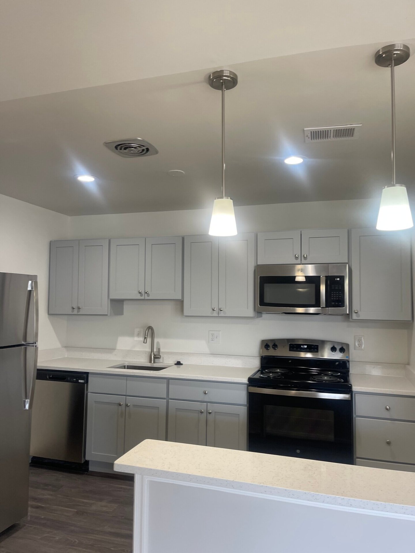 Kitchen with gray cabinets and pendant lights