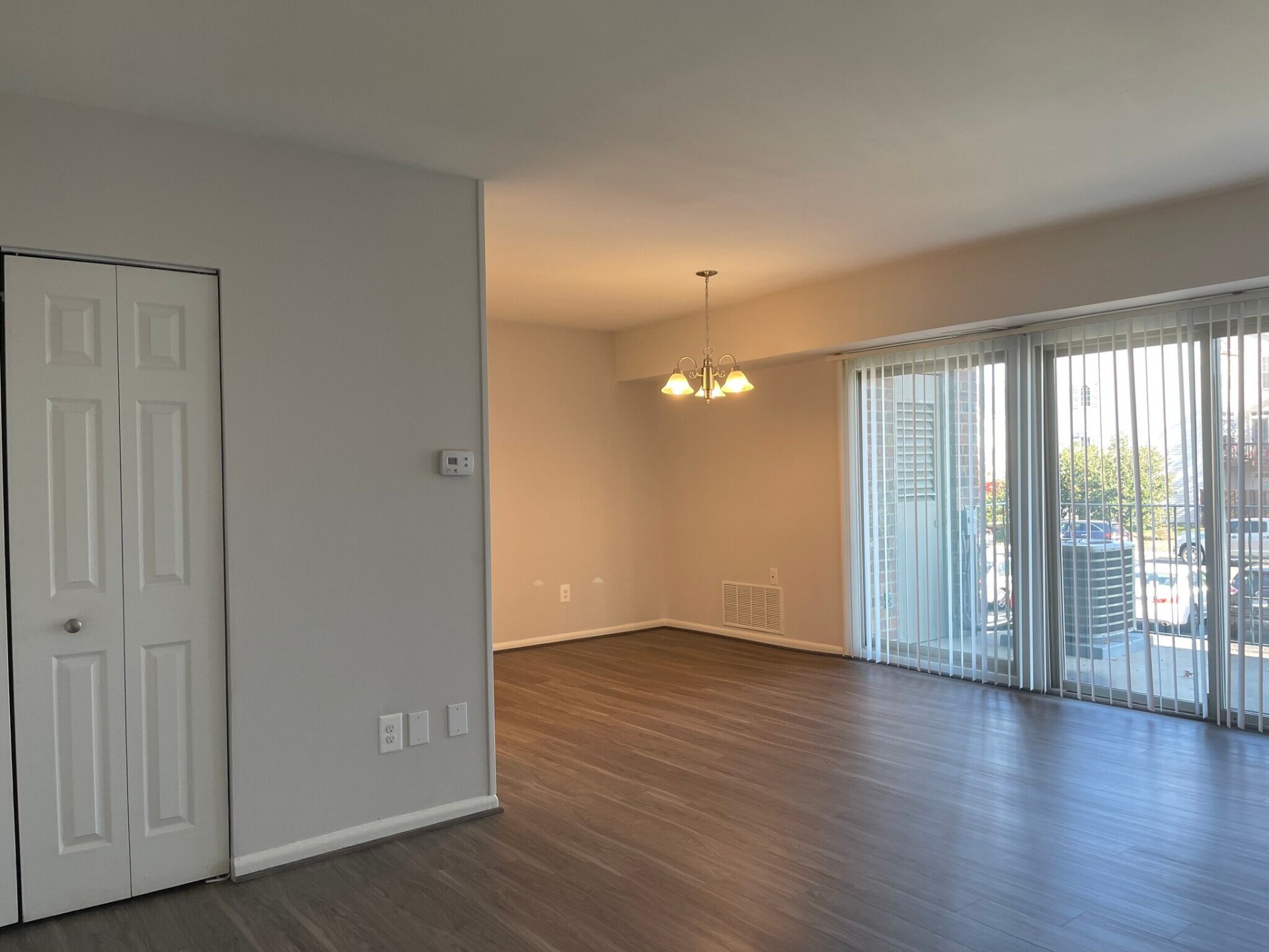 Living and dining area with wood-look flooring and balcony doors