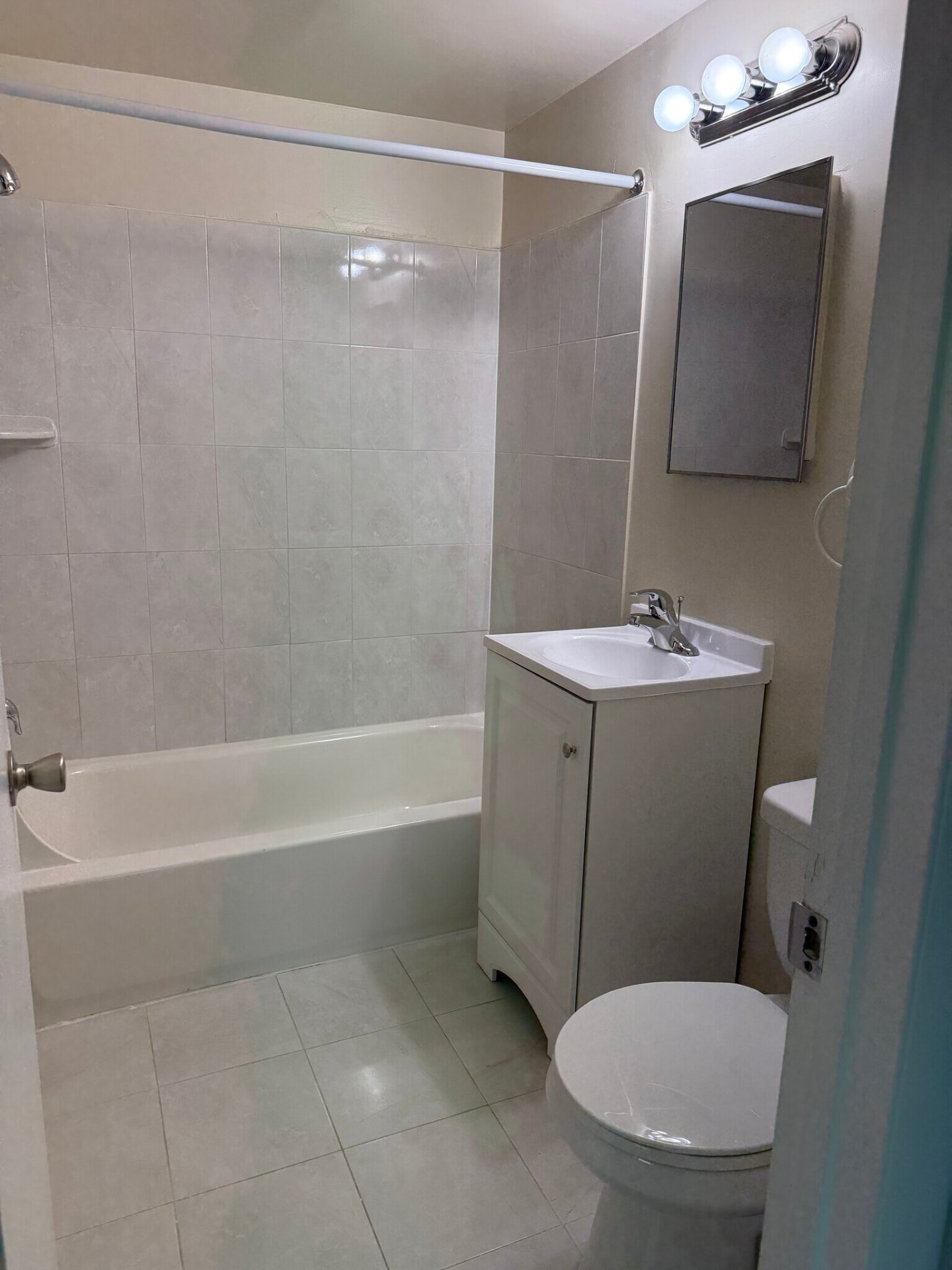 Bedroom bathroom with white vanity and tiled shower