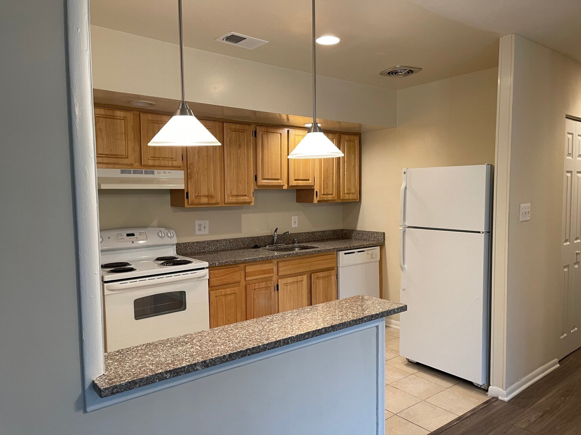 Oak kitchen cabinets viewed through the breakfast bar opening